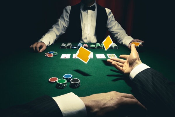 Player throwing a loosing Black Jack hand towards the casino dealer.