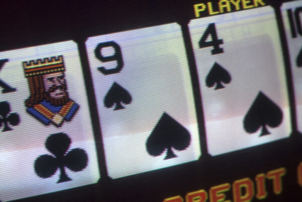 macro close up of a video poker machine with king , a nine and four in a black background