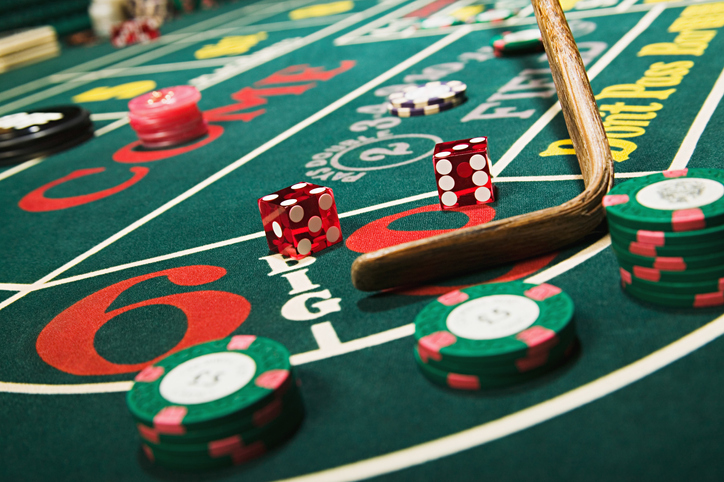 Craps table with dice and poker chips. Players using the Oscar betting system.