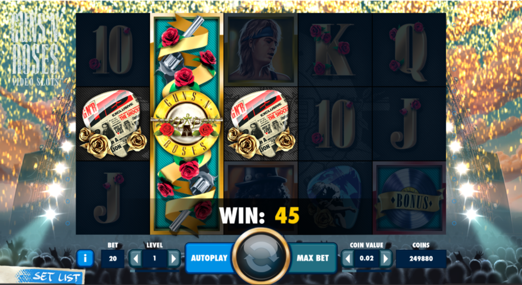 An image of the Guns and roses NetEnt slots game. The background is of a concert. The grids have the letter Q,J,A,K, the guns and roses logo and a guitar chip. 