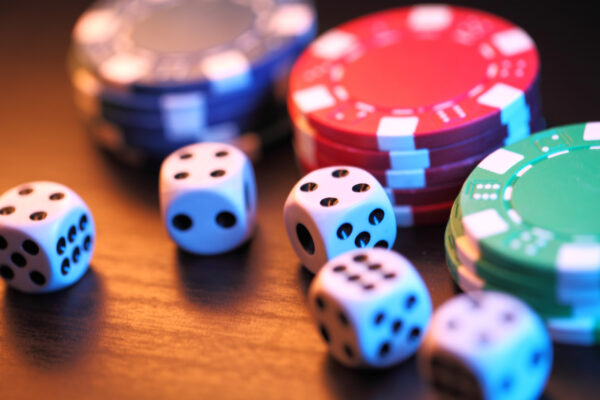 Close up of red, green and blue chips and 5 dices to play blackjack rules