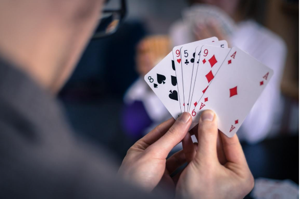 close up of a man card counting, holding 5 cards