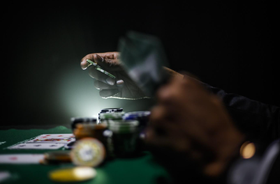gambling in the dark, hands holding cards and chips 