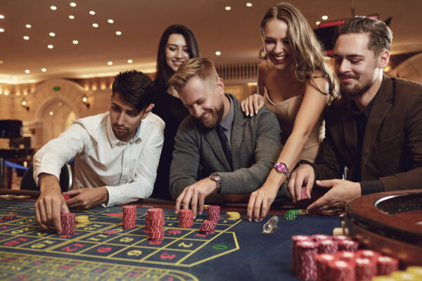 Happy friends play roulette in a casino at a casino party