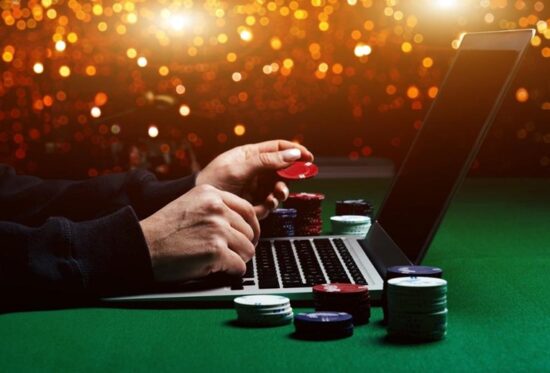 an i image of a hand typing on a laptop with poker chips, he's betting outside the box