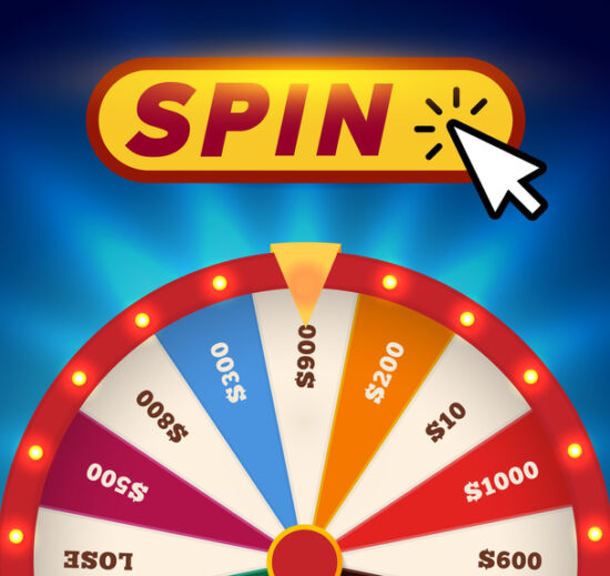An image of a multi coloured spinning wheel, with the text "Spin" at the top with a mouse point