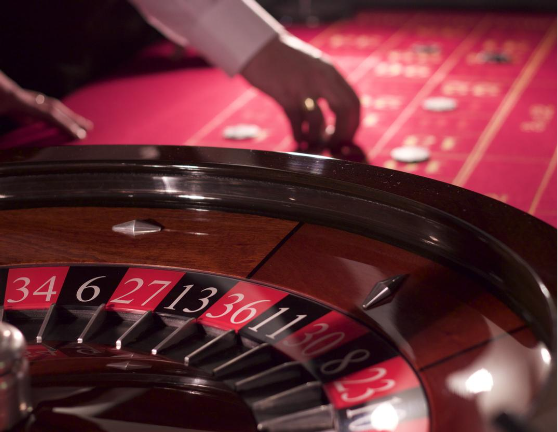 red roulette table with a roulette, making a street bet