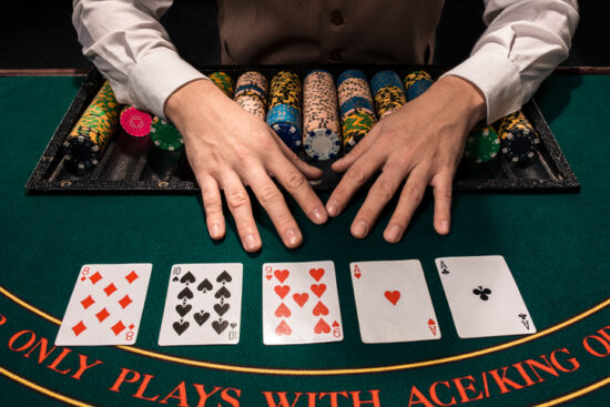 Close up of holdem dealer with playing cards and chips on green table, players using hard and soft hands
